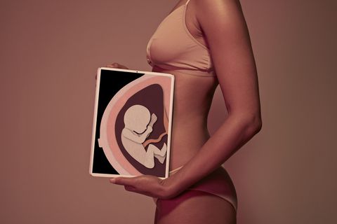 Pregnant young woman holding tablet in front of belly to display baby Pregnant young woman holding tablet in front of belly to display baby
